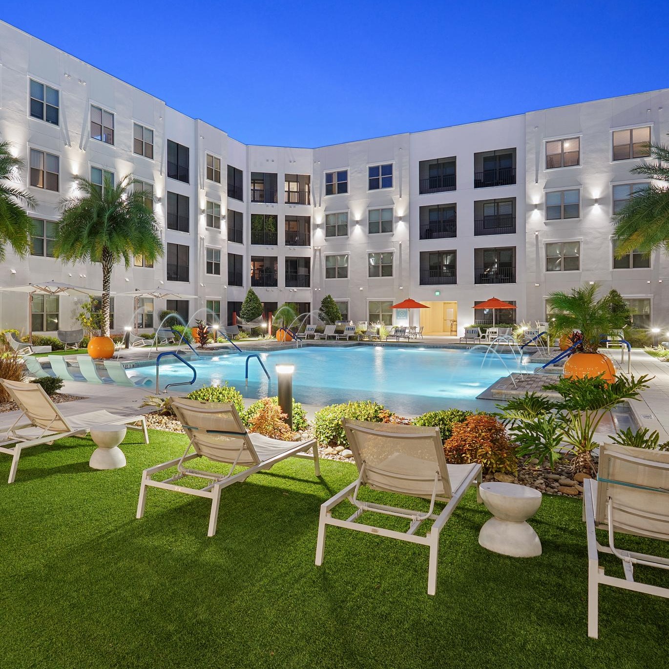 a pool and chairs outside of a building